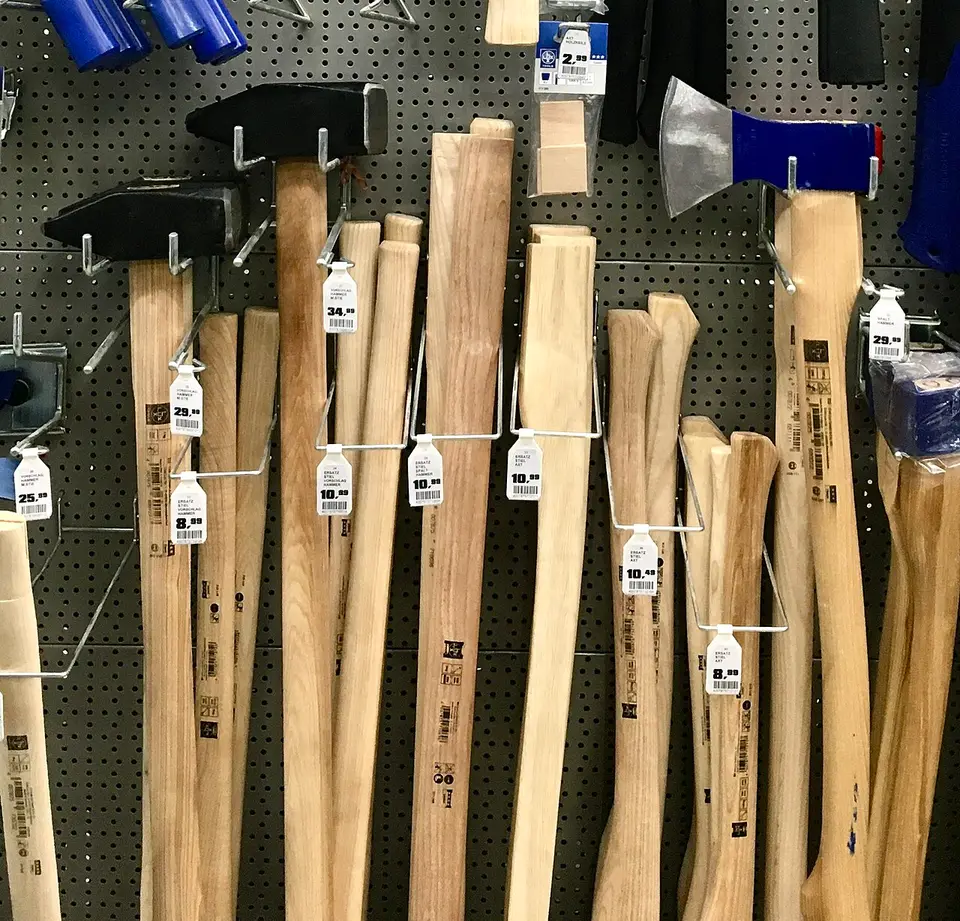 Martillos y mazas con mango de madera colgados en una ferretería